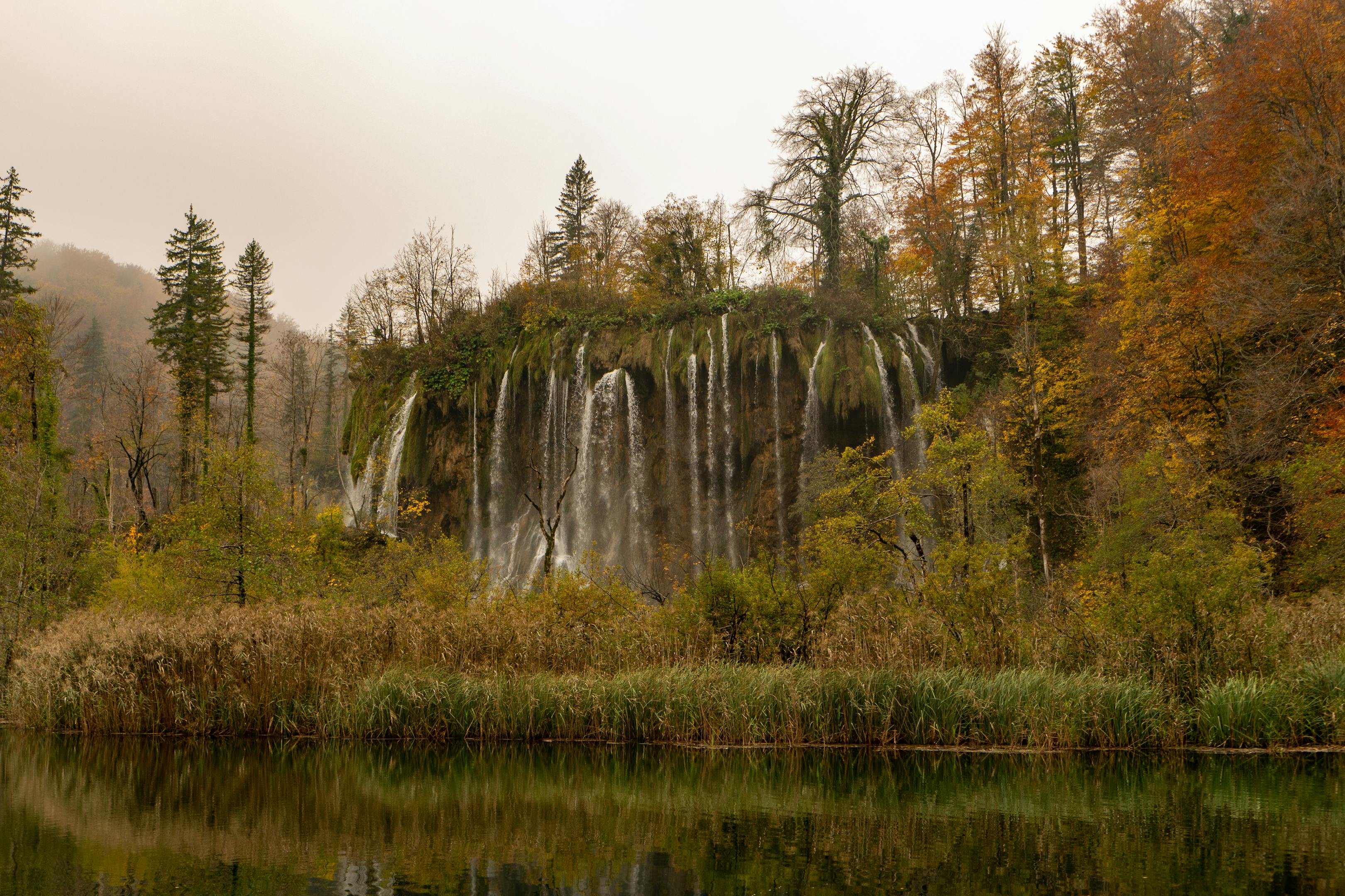 Stunning autumn scene at Plitvice Lakes National Park with a waterfall and colorful foliage