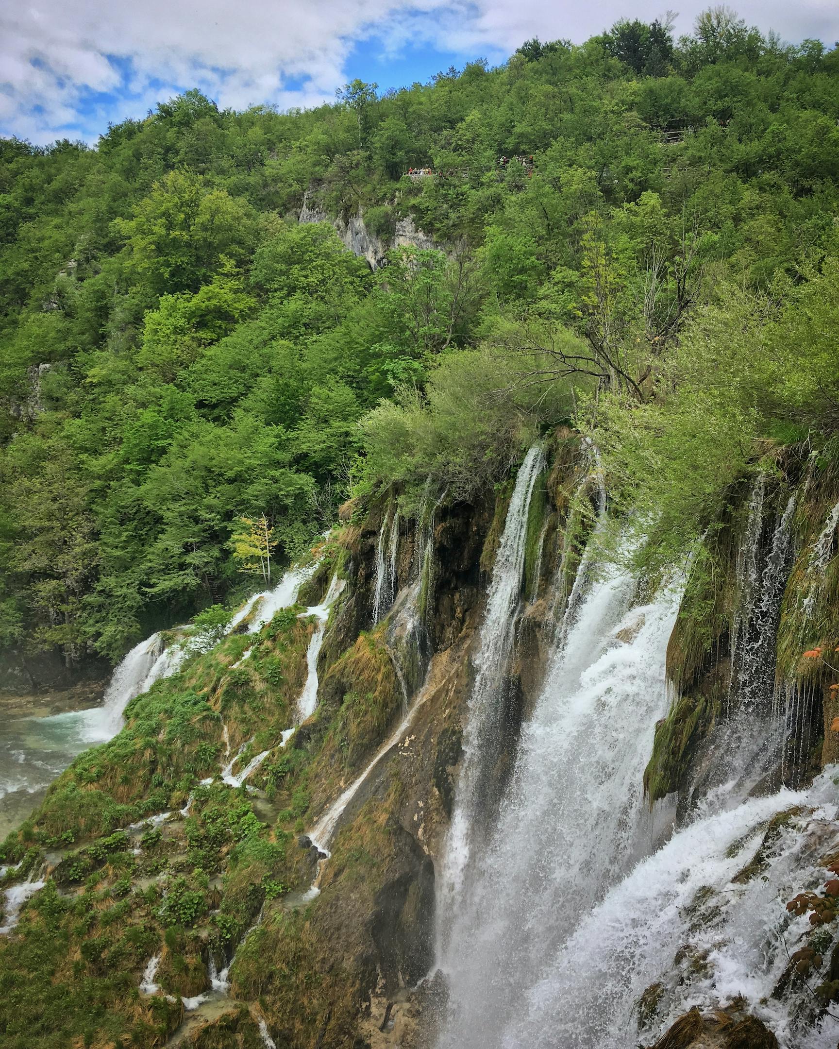 Serene view of cascading waterfalls surrounded by lush greenery in Plitvice Lakes National Park