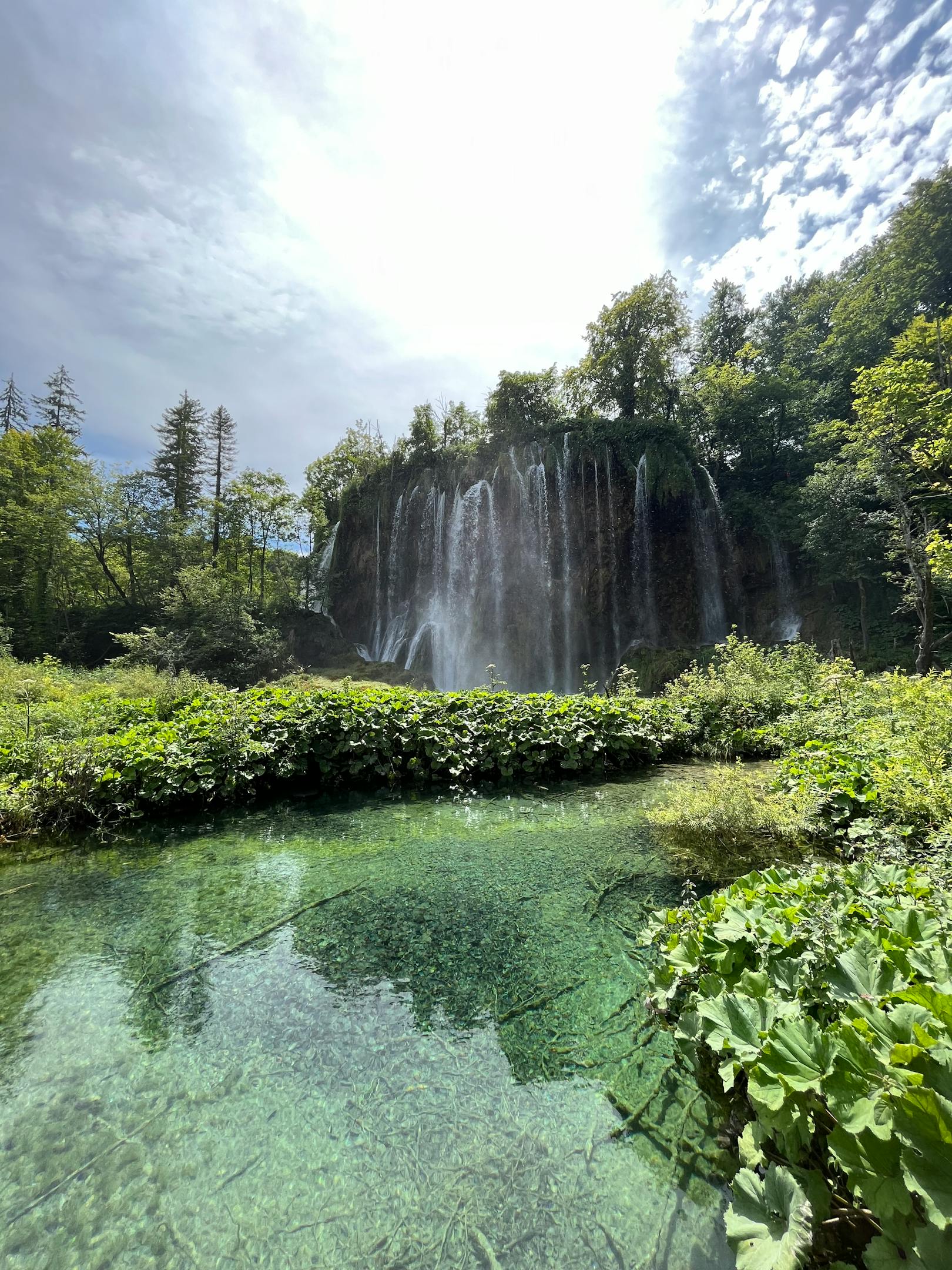 Beautiful waterfall cascading into a clear pond at Plitvice Lakes
