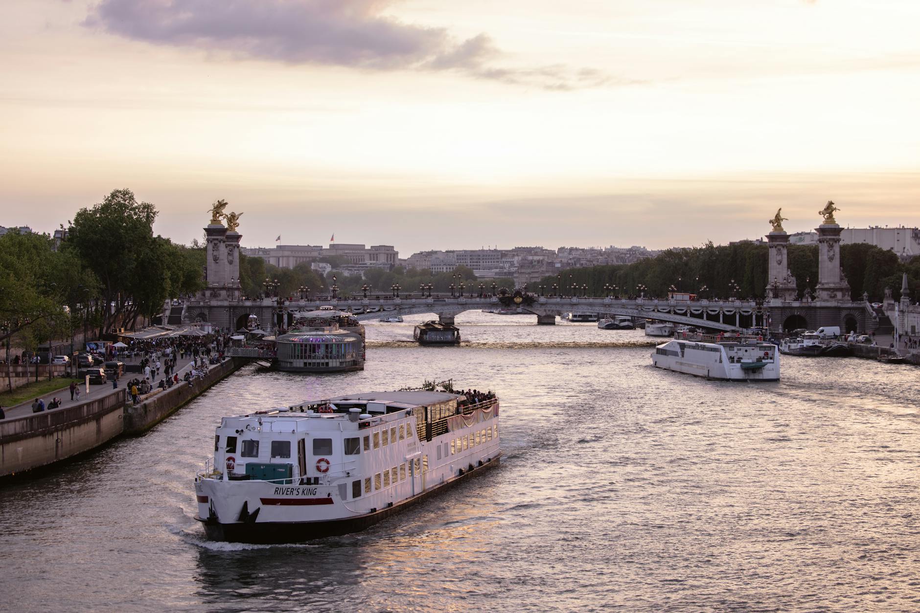 Sunset view of Pont Alexandre III over the Seine with boats