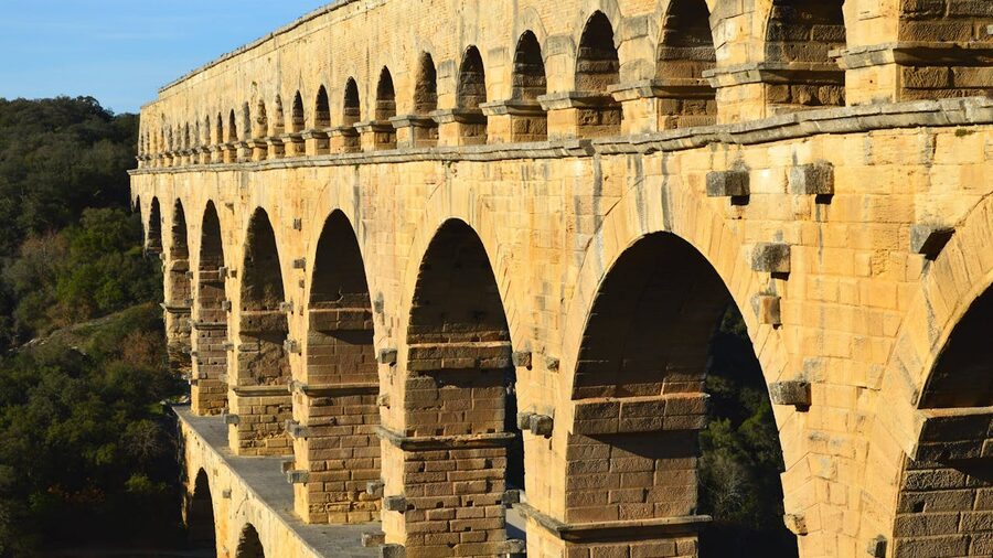 Pont du Gard in sunlight amid lush scenery