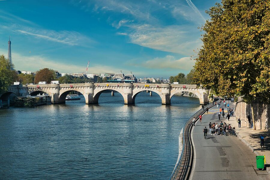 Daytime view of Pont Neuf with cyclists along the Seine