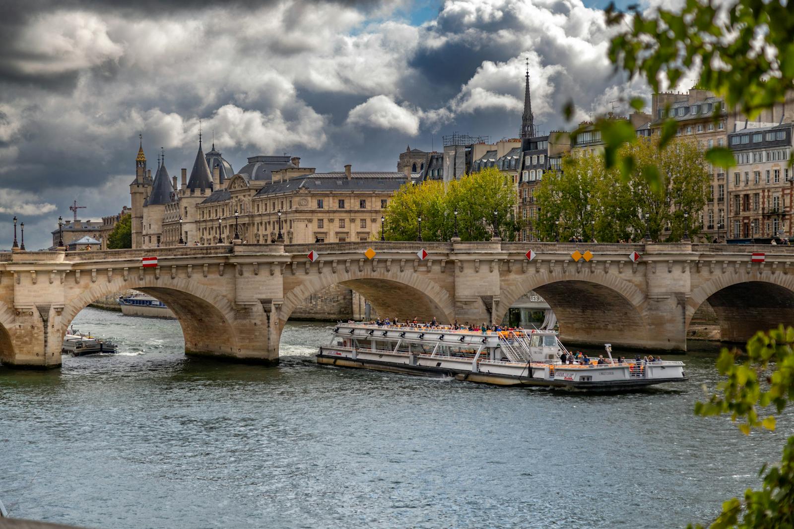 Pont Neuf in Paris with a Seine sightseeing cruise boat passing underneath