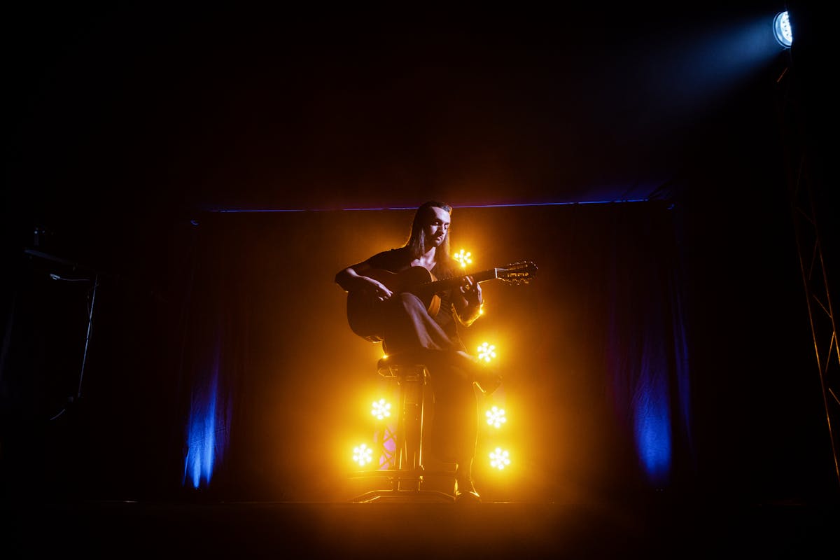 Musician performing in atmospheric yellow and blue stage lighting