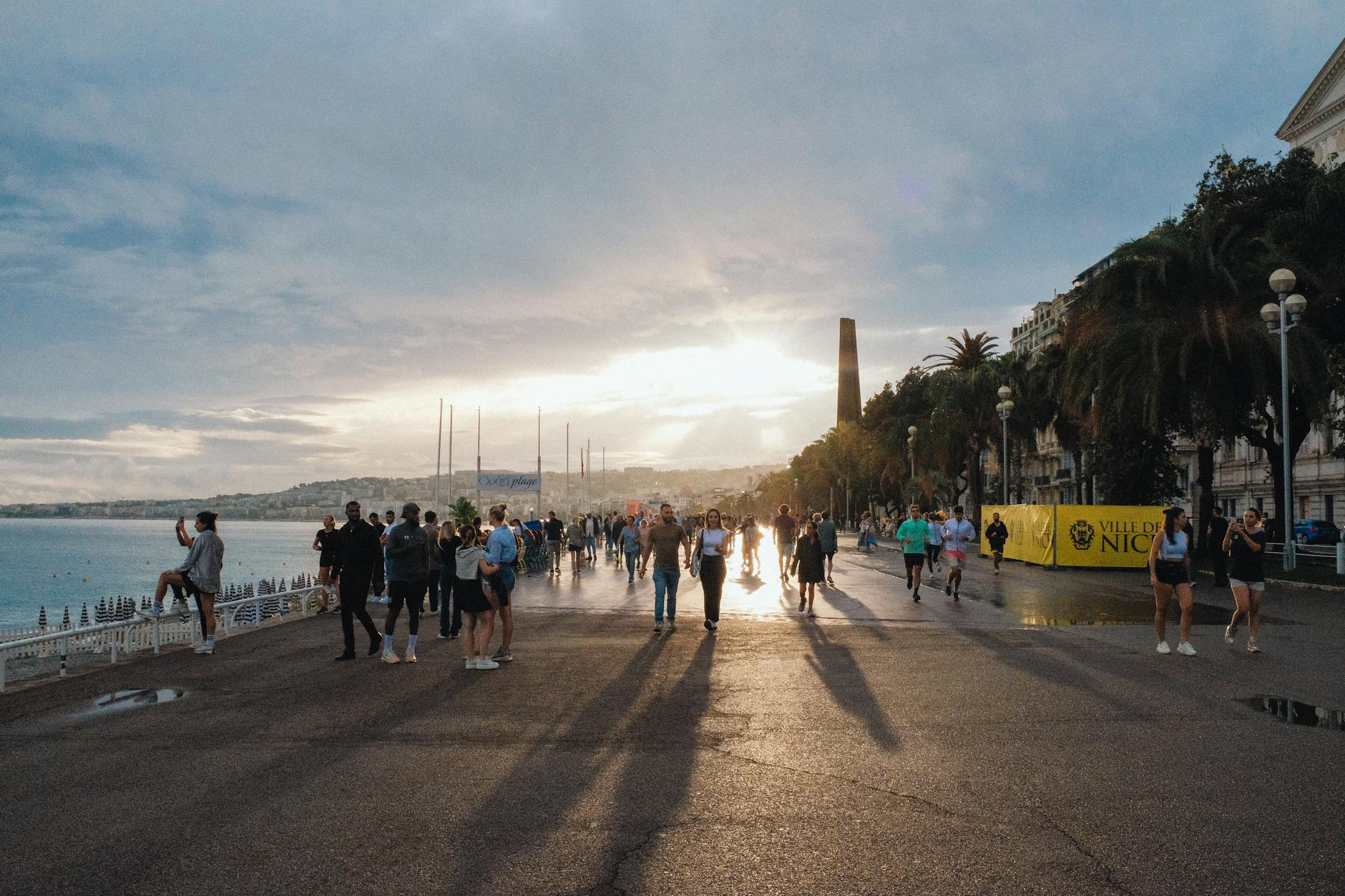 People strolling on the Promenade des Anglais in Nice at sunset