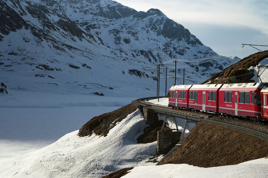 Red Bernina Express traversing snowy mountains in winter