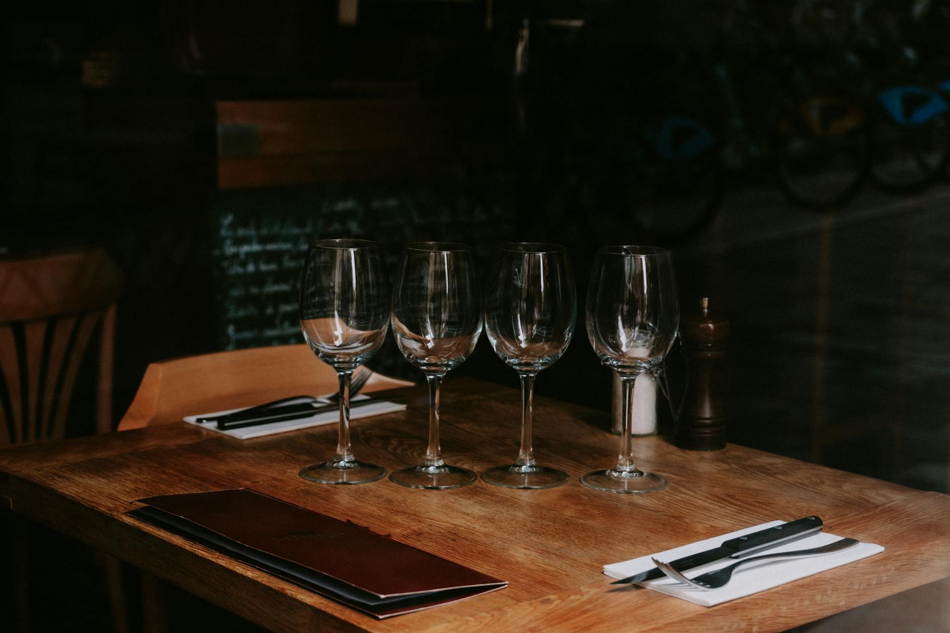 Restaurant wine glasses on a neatly arranged table in a dimly lit setting