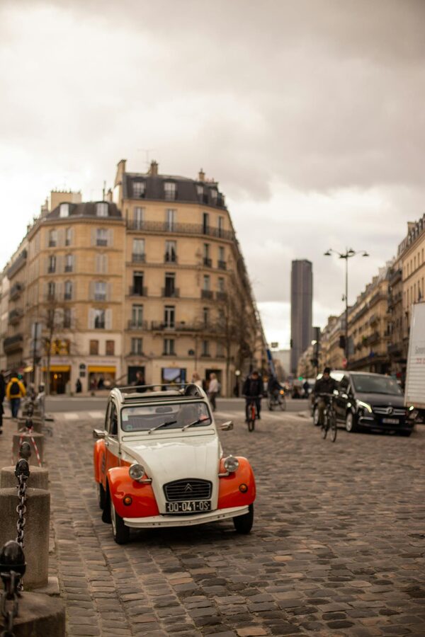 Retro Citroen 2CV on cobblestone street with Paris architecture