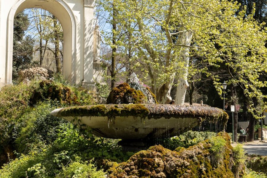 Sunlit fountain in Roman park with greenery