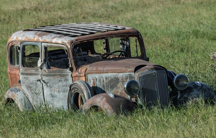 Rusted vintage car in a field