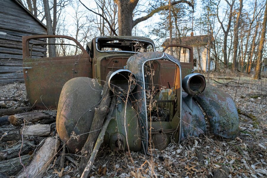 Rusted vintage car in woodland
