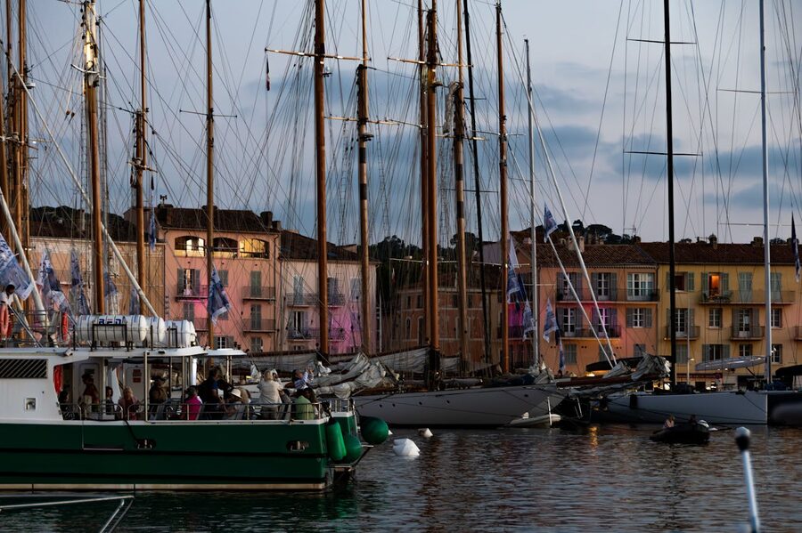 Evening view of boats docked at Saint-Tropez marina with colourful buildings
