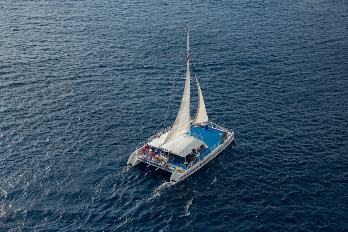 Catamaran sailing with passengers on a clear blue sea