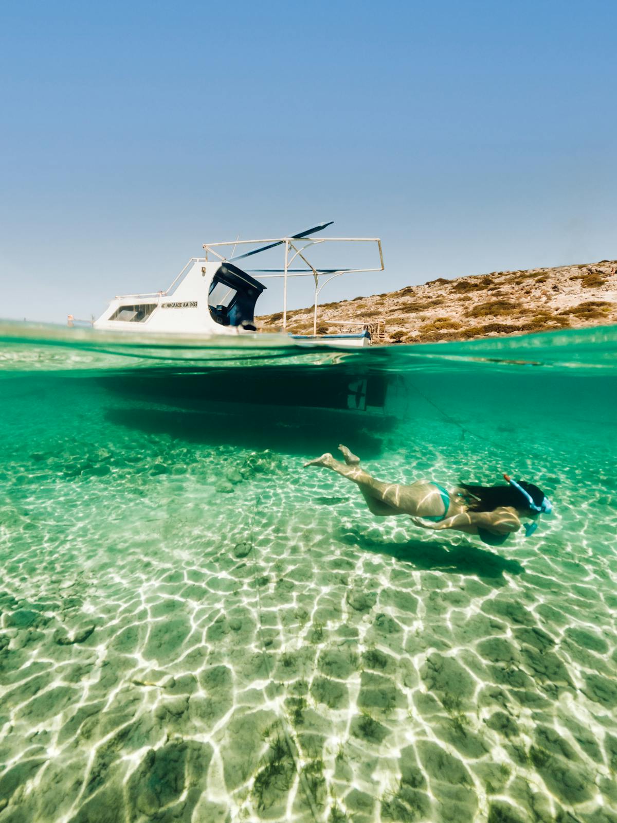Snorkeling in crystal clear waters with a boat visible above