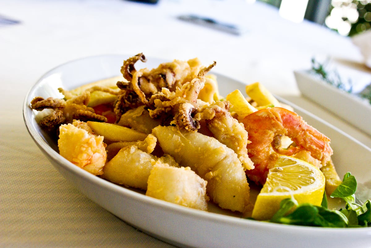 Fried seafood platter with shrimp and calamari garnished with lemon