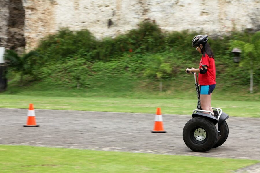 Beginner riding a Segway on a paved path with helmet