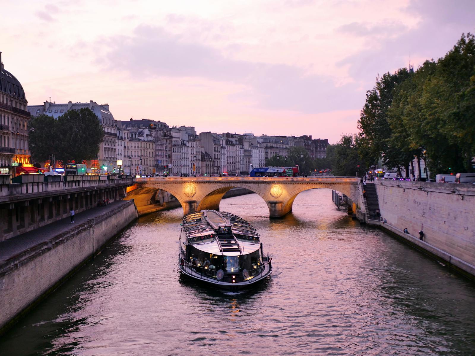 Serene daytime view of the Seine River with a boat passing Parisian architecture