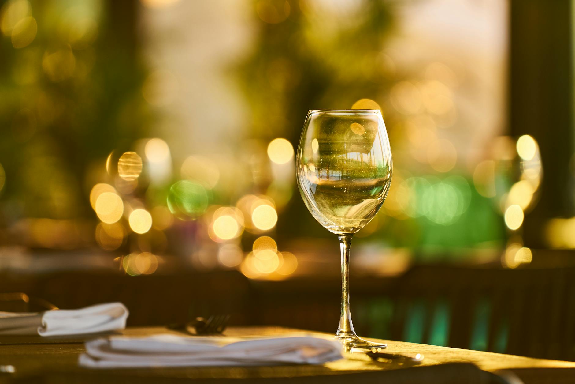 A sparkling wine glass with bokeh lights in a warm indoor setting