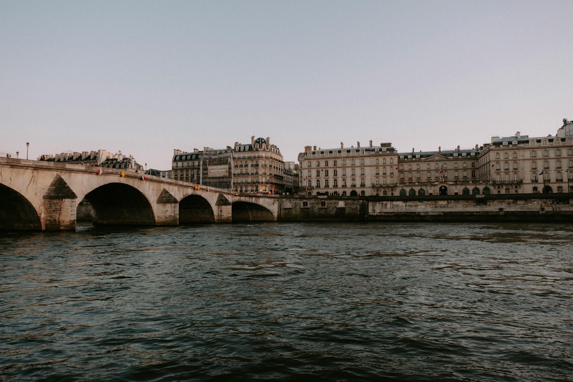 A historic stone bridge over the Seine river in early evening light