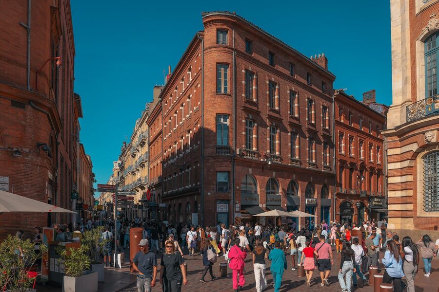 Street scene in Toulouse historic district with crowds and red brick architecture