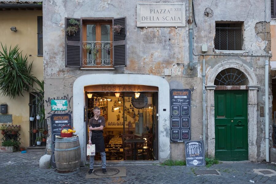 Trastevere rustic restaurant entrance with waiter holding menu