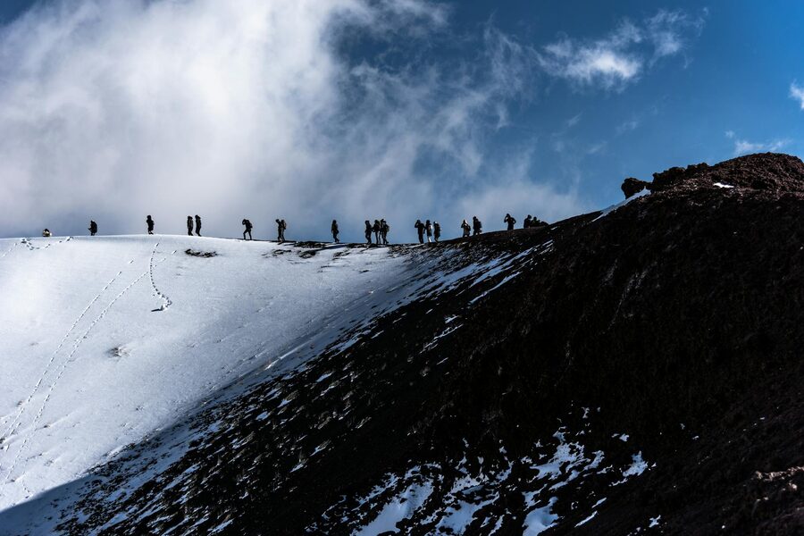 Trekkers on snowy slopes of Mount Etna