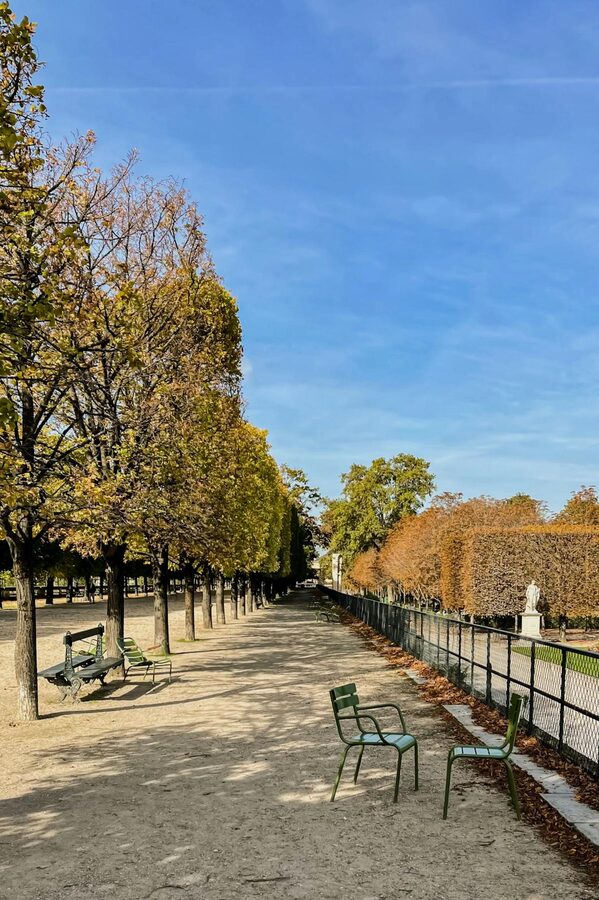 Peaceful park path with chairs and trees in a Paris garden