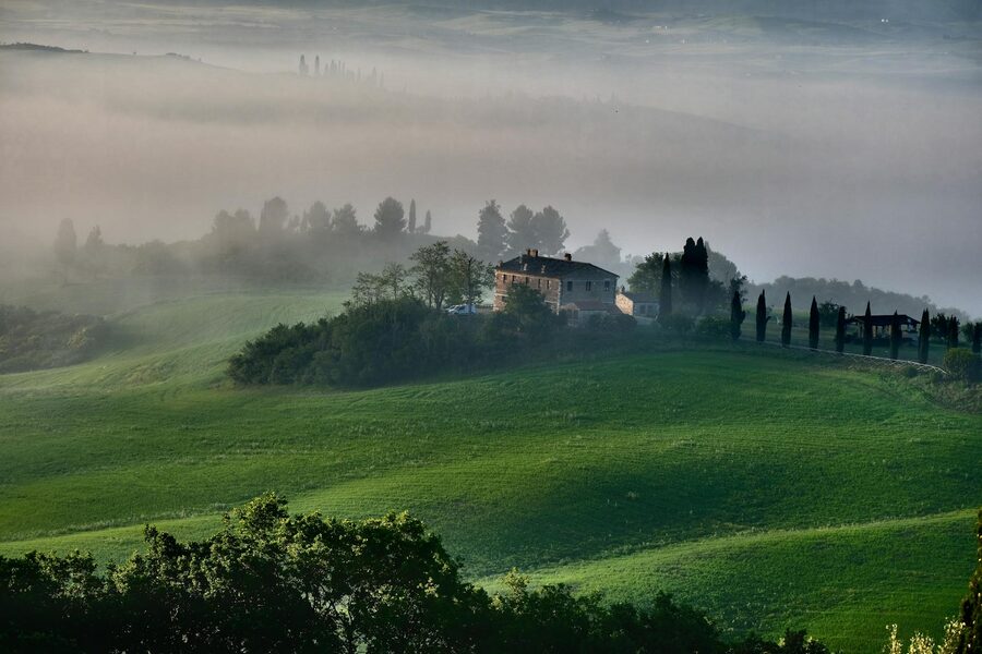 Tuscany misty landscape with farmhouse
