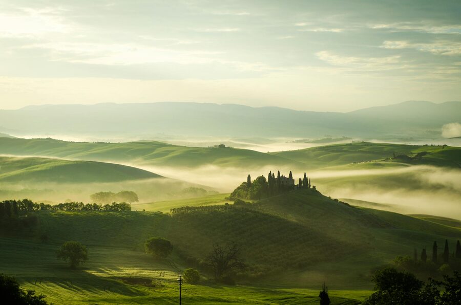 Tuscany morning fog over rolling hills