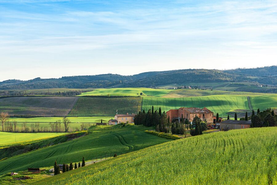 Tuscany farmhouses on rolling hills in springtime