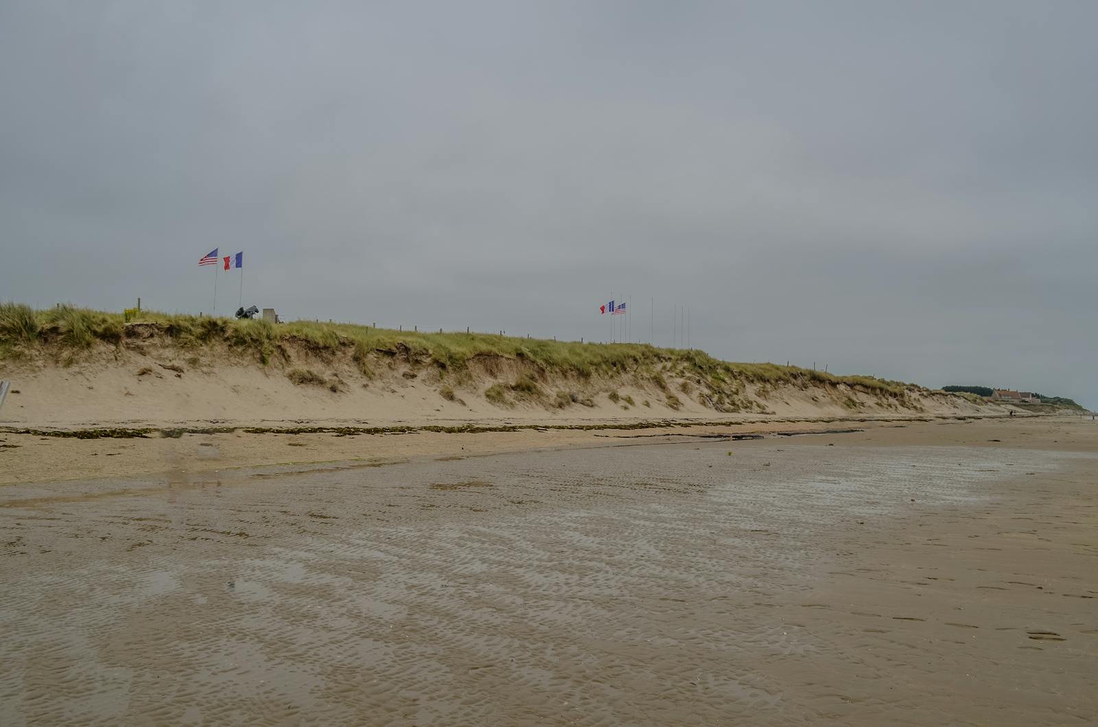 Historic view of Utah Beach in Normandy with American and French flags symbolizing liberation