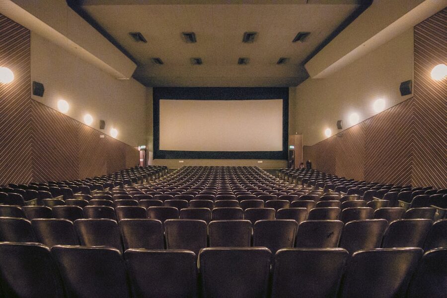 Vacant theater showing rows of seats and a large screen