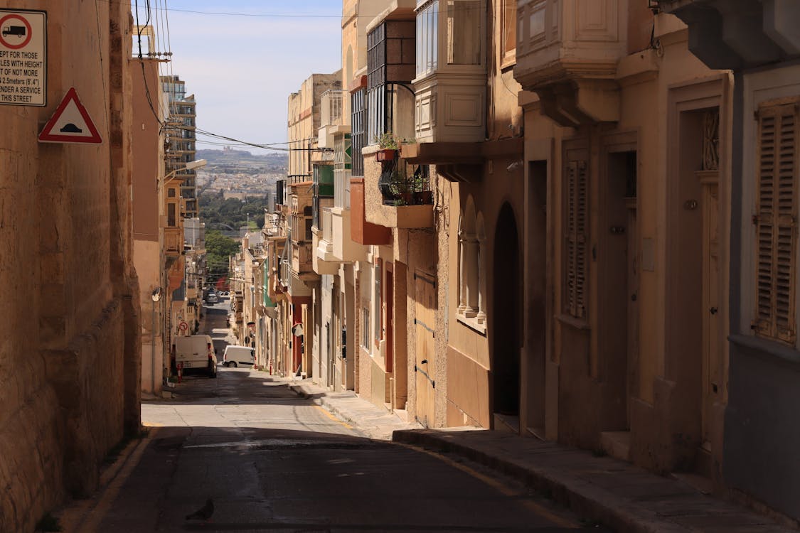Narrow historic street in Valletta with traditional limestone buildings