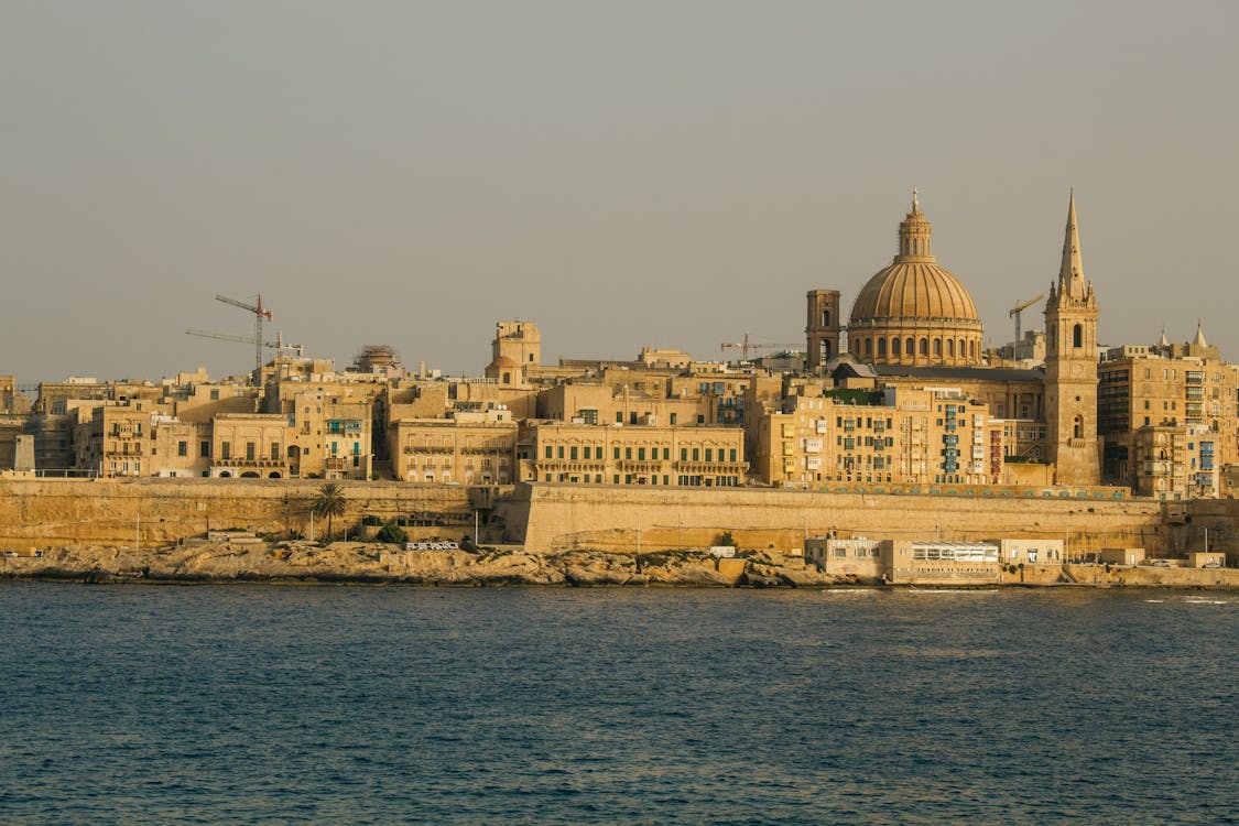 Valletta skyline with cathedral dome silhouetted against a sunset sky
