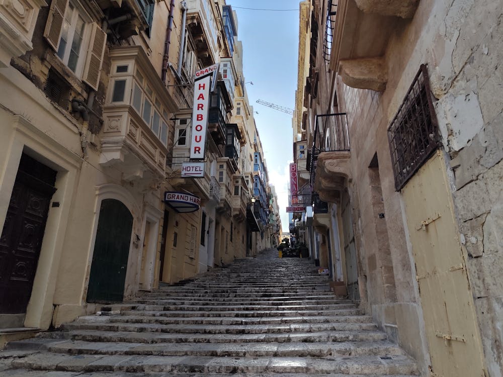 Traditional enclosed wooden balconies lining a stepped street in Valletta