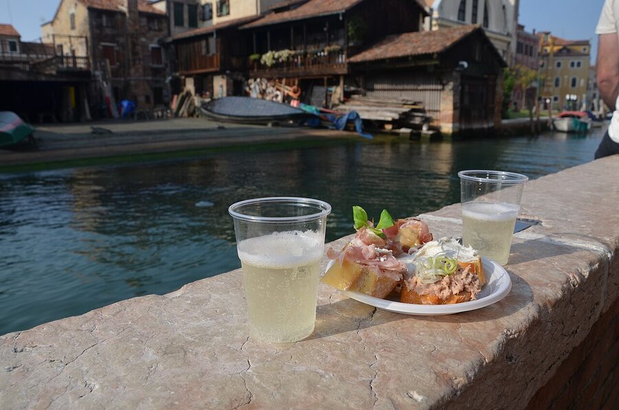 Prosecco glass next to cicchetti plate at Venetian bar