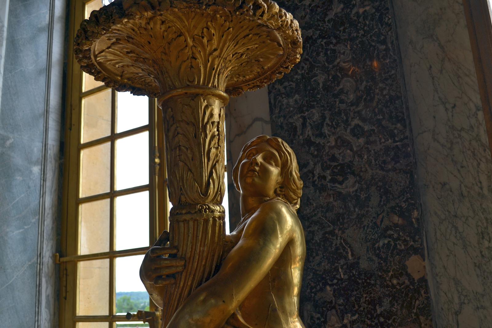 Intricate gold statue detail inside Chateau de Versailles