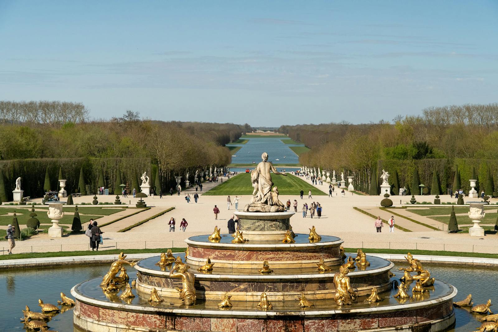 Grand fountain with golden sculptures in the Versailles gardens