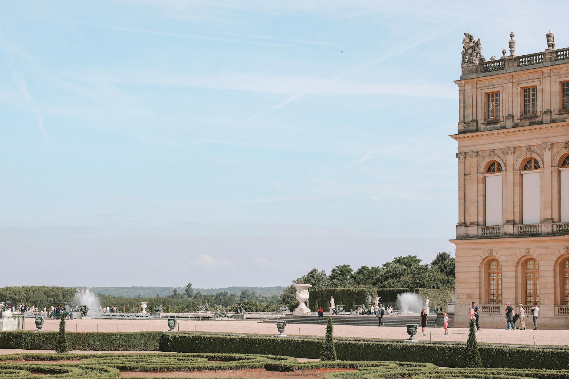 The Palace of Versailles with fountains under a clear sky