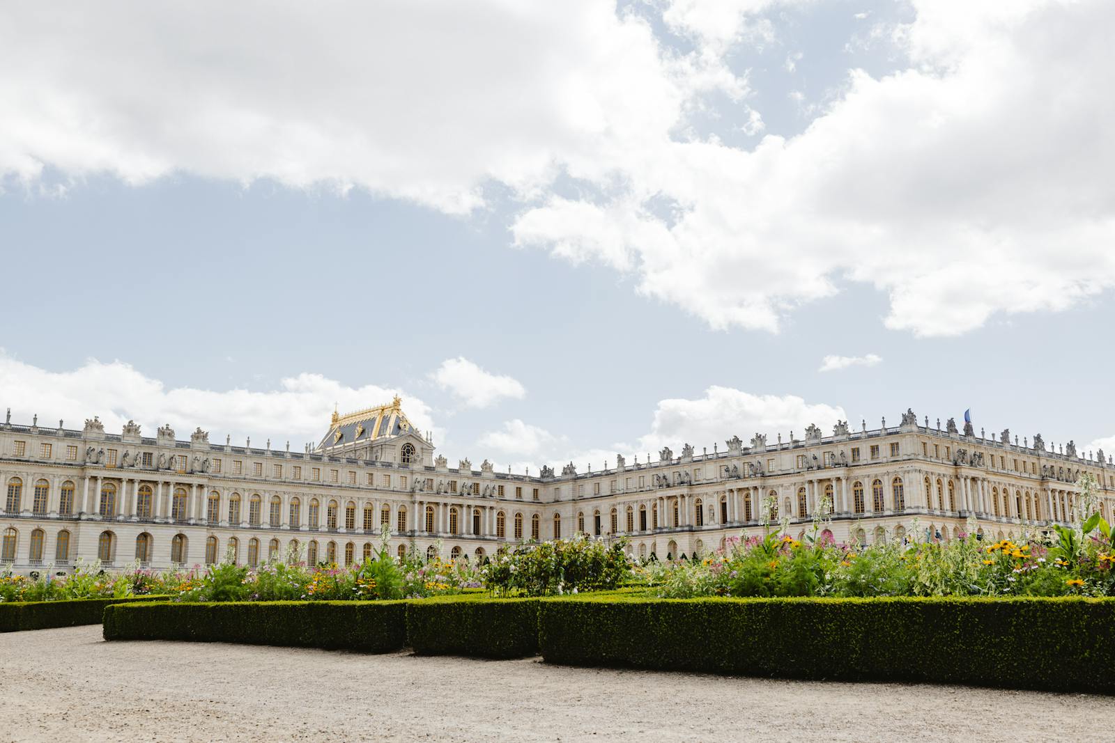 Palace of Versailles with lush gardens under a bright sky