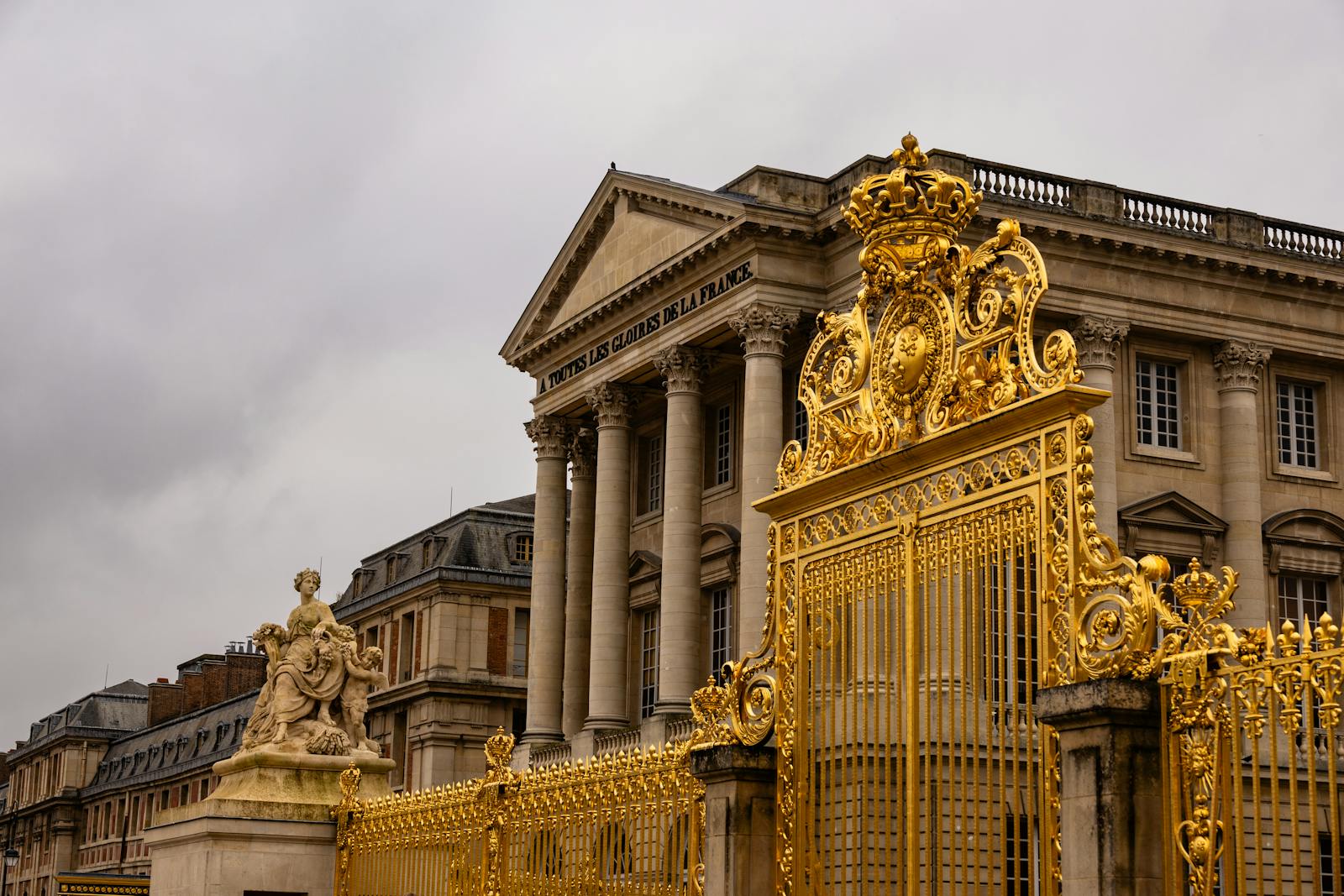 Ornate golden gates at the entrance to the Palace of Versailles