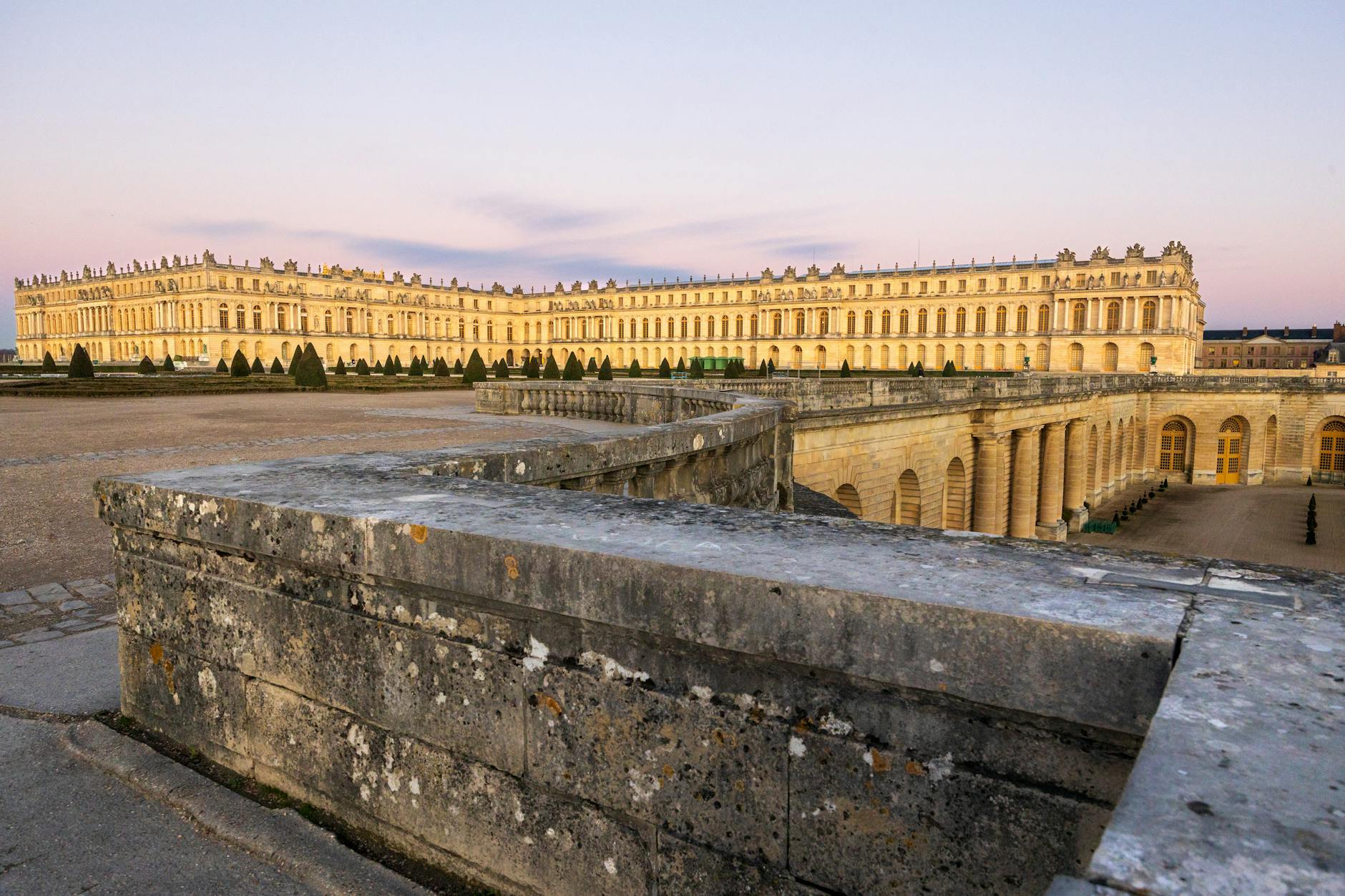 The Palace of Versailles at sunset with warm light on the facade