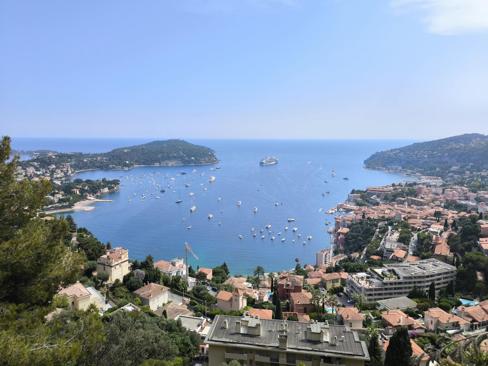 Aerial view of Villefranche-sur-Mer bay with numerous boats and a cruise ship