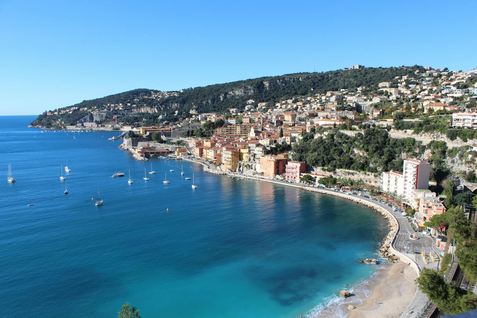 Aerial view of Villefranche-sur-Mer coastline and boats on a clear summer day