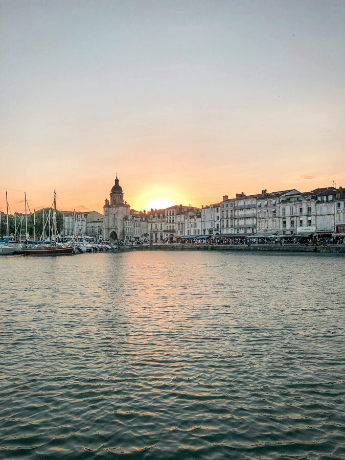 City waterfront at sunset with boats and historic architecture