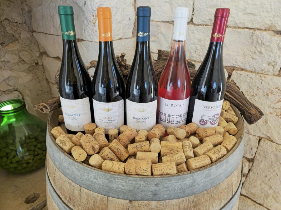 Assorted wine bottles and corks on a wooden barrel