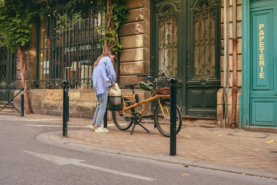 Woman standing by a bicycle on a charming Paris street
