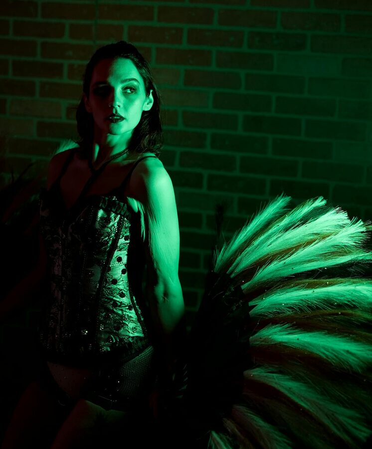 Woman in dramatic lighting wearing a feathered costume