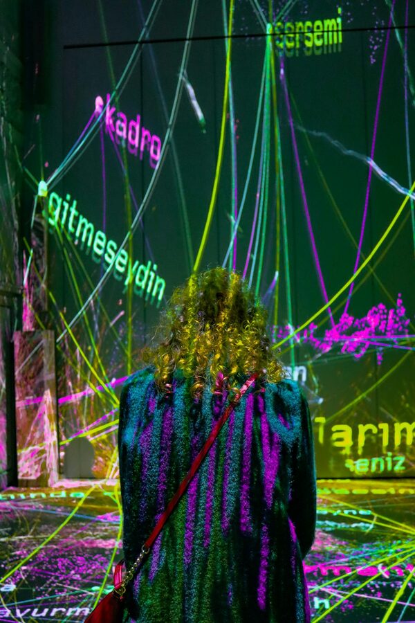 Woman standing before a colourful neon light installation creating an immersive experience