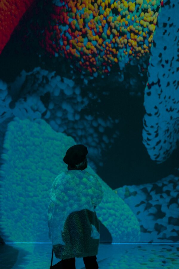 Woman observing abstract projections on a museum wall